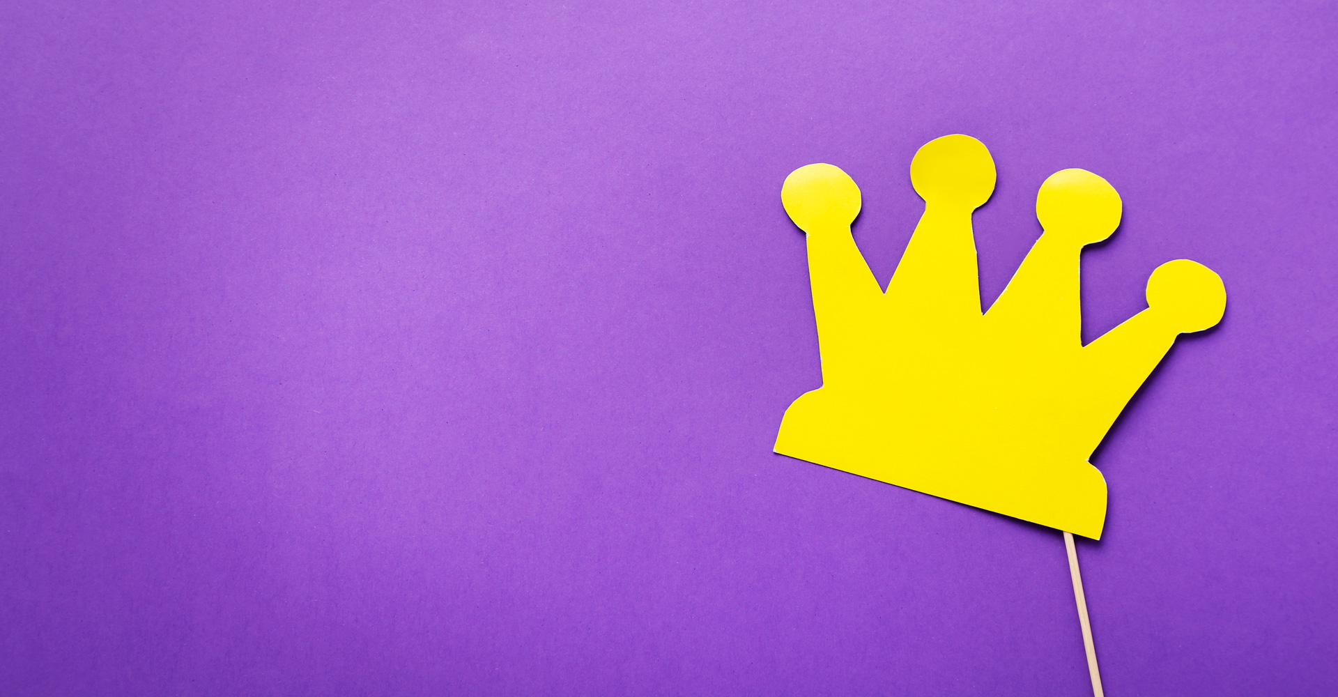 Yellow paper crown on purple background.