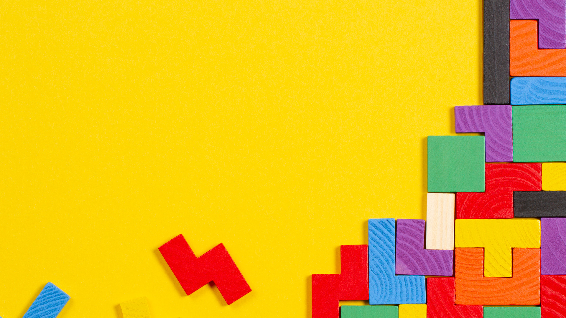 Colorful wooden blocks on yellow background.
