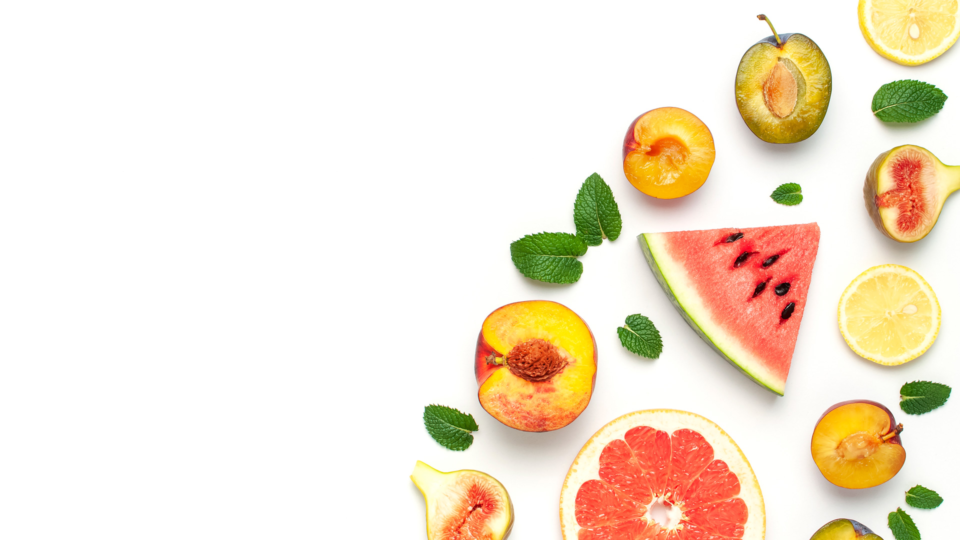 Assorted fresh fruits with mint on white background.