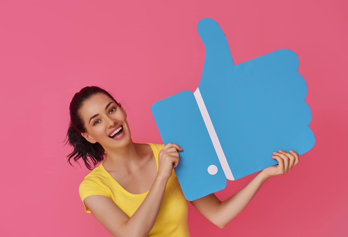 Woman holding Facebook 'tumbs up' icon
